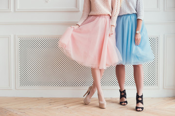 Two girls are posing for a photo. They are showing their legs, f