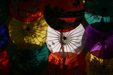 Colorful umbrellas background with shadowy light in darkness  