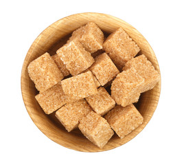 brown sugar cubes in a wooden bowl isolated on white background. Top view. Flat lay