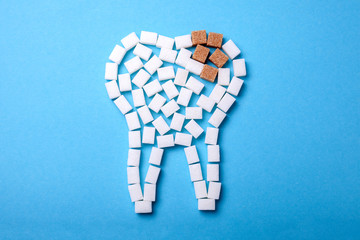 Sugar destroys the tooth enamel and leads to tooth decay. Sugar cubes are laid out in the form of a...