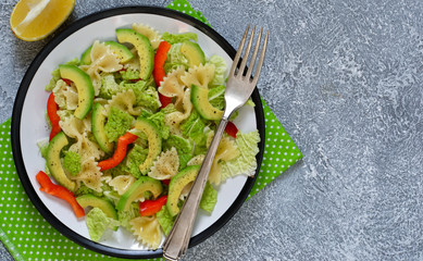 Vegetable salad with china, avocado and pepper on a concrete background.