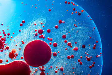 Red bubbles of blood cells on blue background closeup. Abstraction of medicine. Concept of micro...