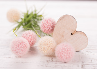 Flowers composition for Valentine's, Mother's or Women's Day. Pink flowers with wooden hearth on old white wooden background.