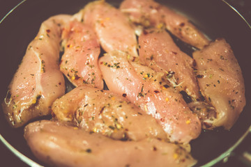 chicken breasts in a frying pan with seasoning