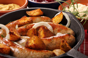 sausages with potatoes baked in a frying pan