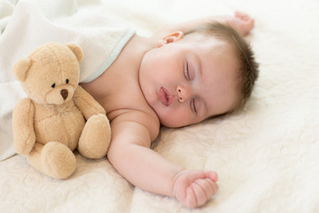 sleeping newborn baby with teddy bear
