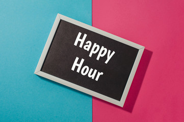 Happy hour - text on chalkboard on blue and pink bright background.