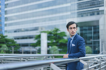 Smart businessman in full suit standing outdoors in cityscape background