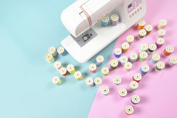 Sewing machine and colorful thread rolls for sewing on two tone background, Sewing and needlework...