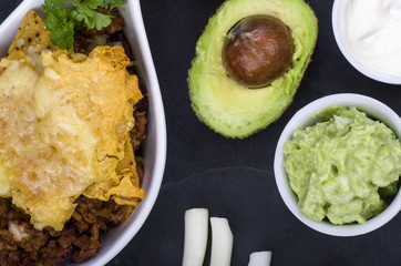 Cheesy Chilli Nachos with Guacamole.
Cheesy Chilli Nachos served in a large spoon with sides of guacamole, Sour Cream, Avocados and Spring Onion. A quick St. Patrick’s Day snack.