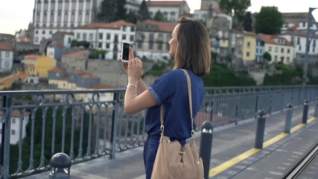 Woman taking photo of Porto view with cellphone
