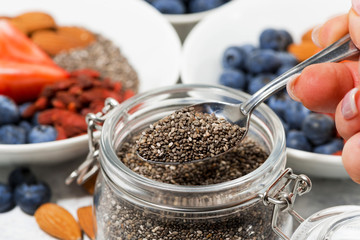 chia seeds in a jar, berries and nuts for a healthy breakfast, closeup