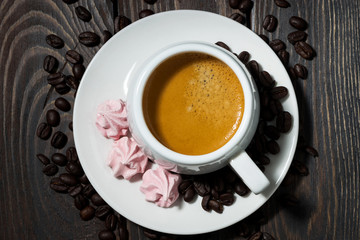 cup of espresso and pink meringues, top view