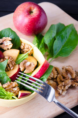 Spinach salad with nuts and apples served on table