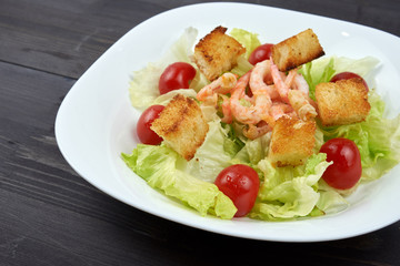 Caesar salad with shrimp on white plate