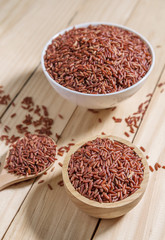Rice berry in wooden bowl on wood background