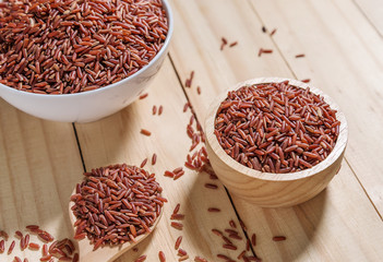 Rice berry in wooden bowl on wood background