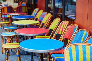 Fototapeta na wymiar Colorful tables and chairs of outdoor cafe in Paris
