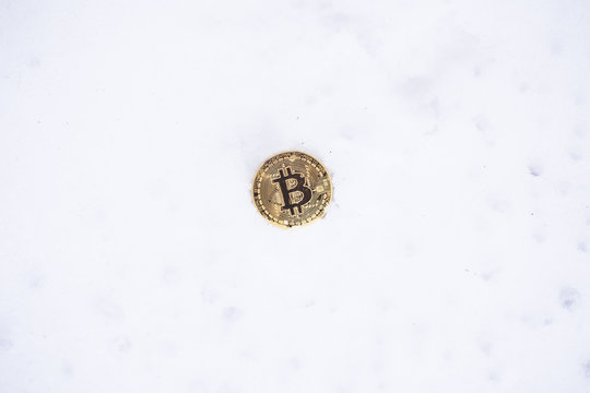Bitcoin on the snow. Isolated on white background.