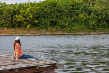 alone lady feel relax sit on wood ralf and look out lake view