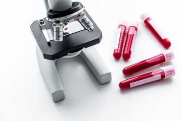 Blood test concept. Blood samples near microscope on white background top view