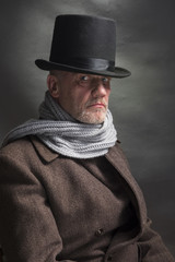 Portrait of a sinister man wearing a top hat and a grey scarf