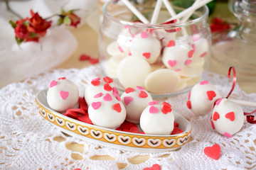 Obraz na płótnie Canvas White chocolate sweets and cake pops decorated with little confectionery hearts