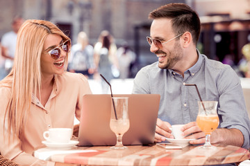Couple enjoying the wireless internet at cafe.