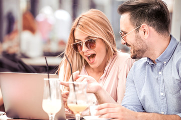 Couple in cafe with laptop.
