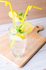 Glasss of mojito with lemon and drinking straw