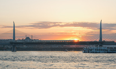 Fototapeta premium Subway bridge on the the Golden Horn and cityscape at sunset, Istanbul, Turkey.