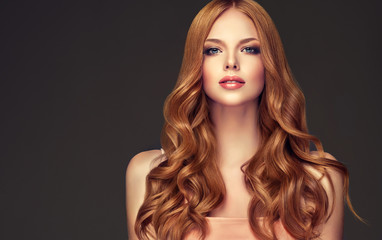 Fille rousse aux cheveux ondulés longs et brillants. Belle femme modèle avec une coiffure frisée.