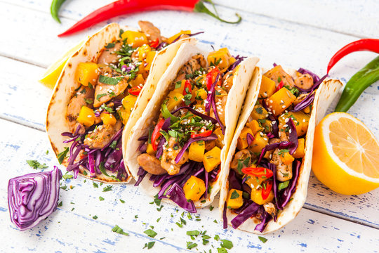 Mexican pork tacos with vegetables and pumpkin. Tacos on wooden white rustic background. Top view.