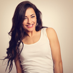 Fototapeta premium Beautiful positive laughing young woman in white shirt and long hair toothy smile. Toned vintage portrait
