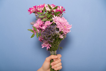 Woman's hand with a flowers bouquet