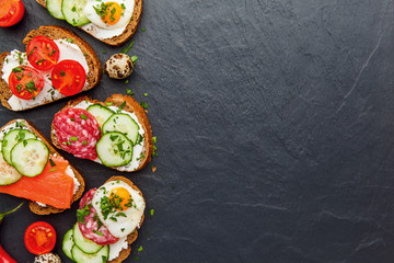 Homemade bruschetta. Mini sandwiches. Traditional spanish tapas on dark table. Brushetta set.