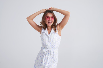 Pretty woman in pink sunglasses having fun while posing