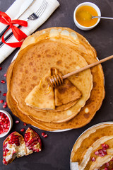 Homemade crepes with honey and ingredients over rustic background. Maslenitsa. Russian folk festival