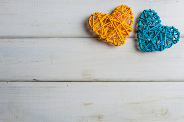 Colorful wooden hearts on white boards background