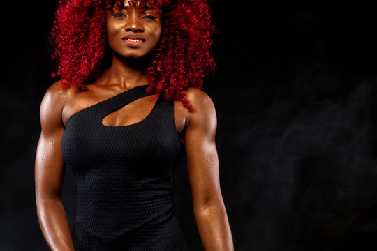 A strong athletic woman on black background wearing in white