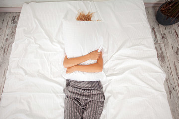 Tired woman on the bed - obrazy, fototapety, plakaty