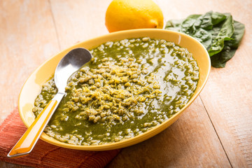 soup with barley spinach and  lemon, selective focus