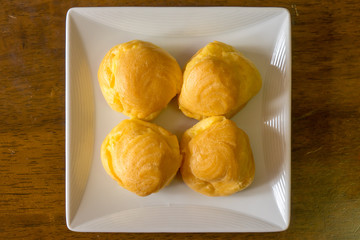 Choux cream puffs on white square plate