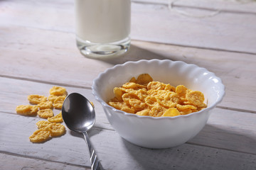 Corn Flakes cereal in a bowl and glass with milk. Morning breakfast.