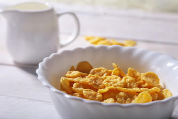 Corn Flakes cereal in a bowl and glass with milk. Morning breakfast.