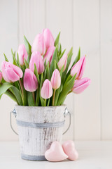 Spring easter tulips in bucket on white vintage background.