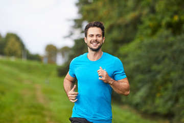 Happy man running in park during summer