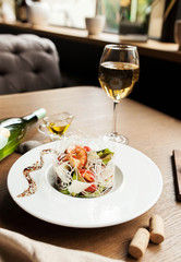 beautiful salad with seafood with a glass of white wine on a wooden table - 189078786