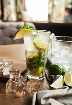 refreshing mojito cocktail with mint lime and ice on a wooden table