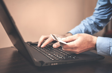 Man holding credit card and using laptop. Online payment and shopping.